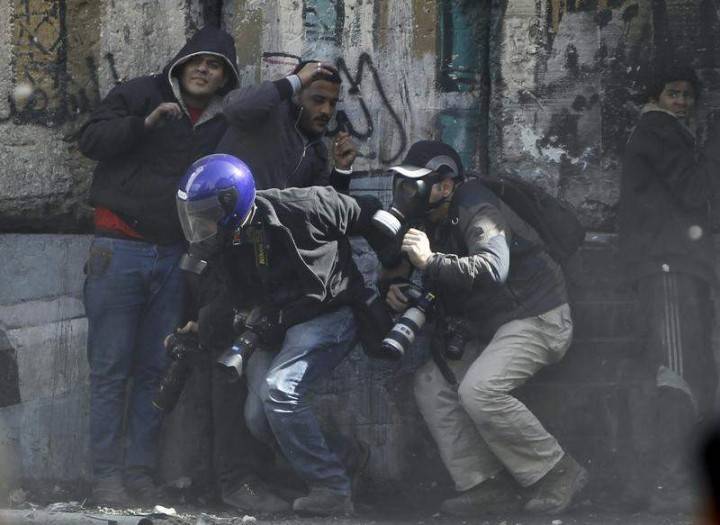 Photographers cower as protesters throw stones towards riot police along Sheikh Rihan street near Tahrir Square in Cairo January 25, 2013. REUTERS/Amr Abdallah Dalsh 